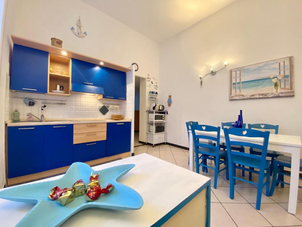 a kitchen with blue cabinets and a table and chairs at CasaViva - Cozy Trilo in Camogli with AC in Camogli