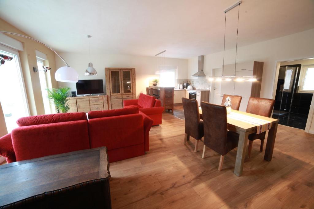un soggiorno con divano rosso e tavolo di Feriendomizil Steffen a Sankt Wendel