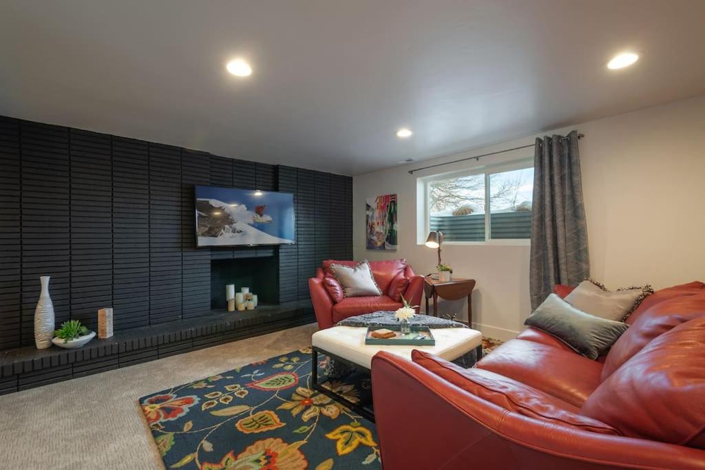 a living room with red leather furniture and a fireplace at Modern Apartment close to freeway! in Salt Lake City