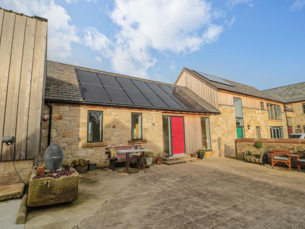 a house with solar panels on the roof at High Barns Cottage in Morpeth