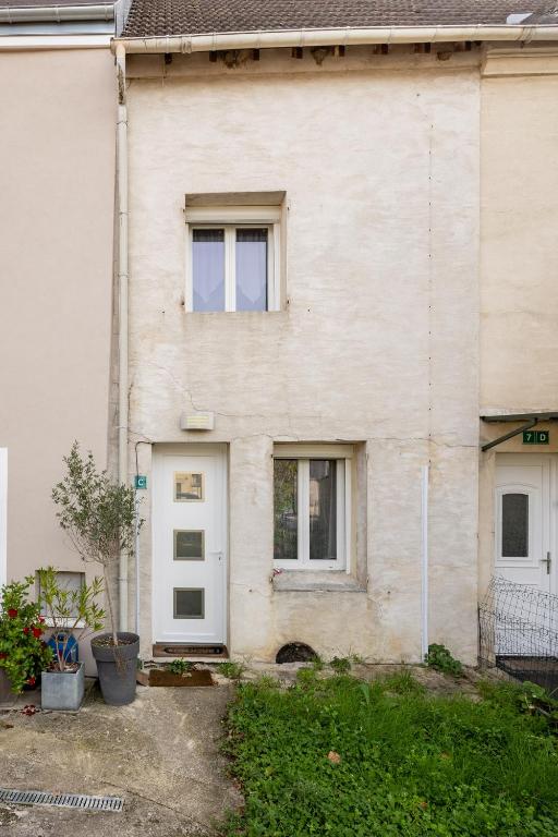 biały budynek z białymi drzwiami i oknami w obiekcie Maison Mareuil w mieście Mareuil-lès-Meaux