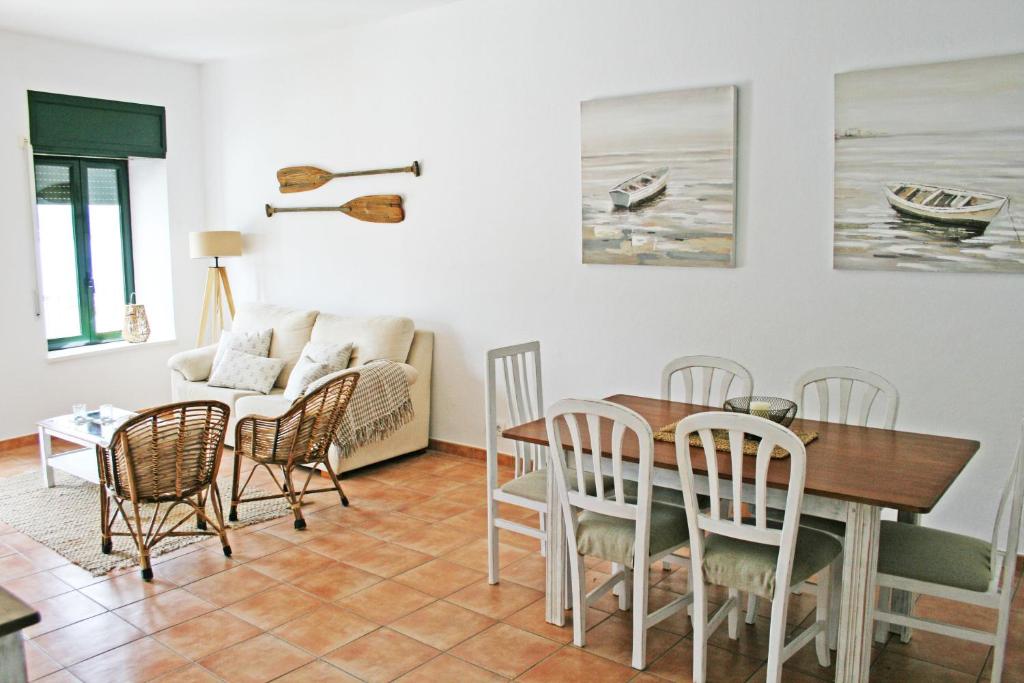 comedor y sala de estar con mesa y sillas en Apartamento con vistas al mar 2 en Port de la Selva