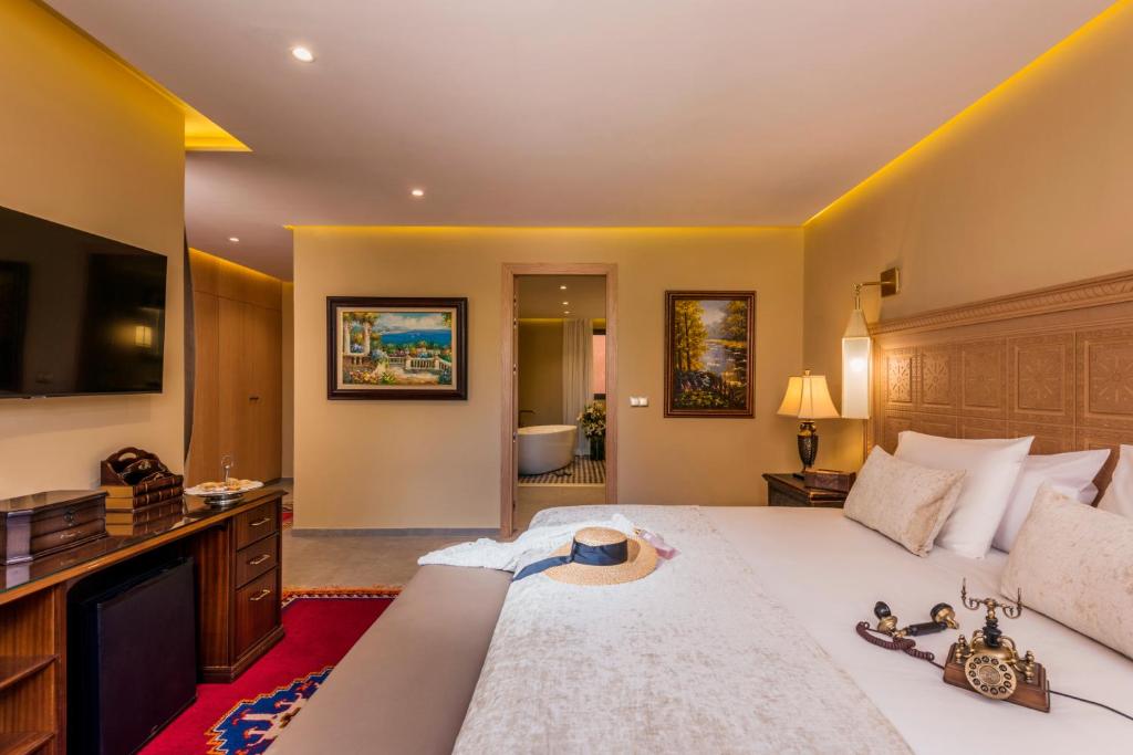 a bedroom with a large bed with a hat on it at Berbère Palace in Ouarzazate