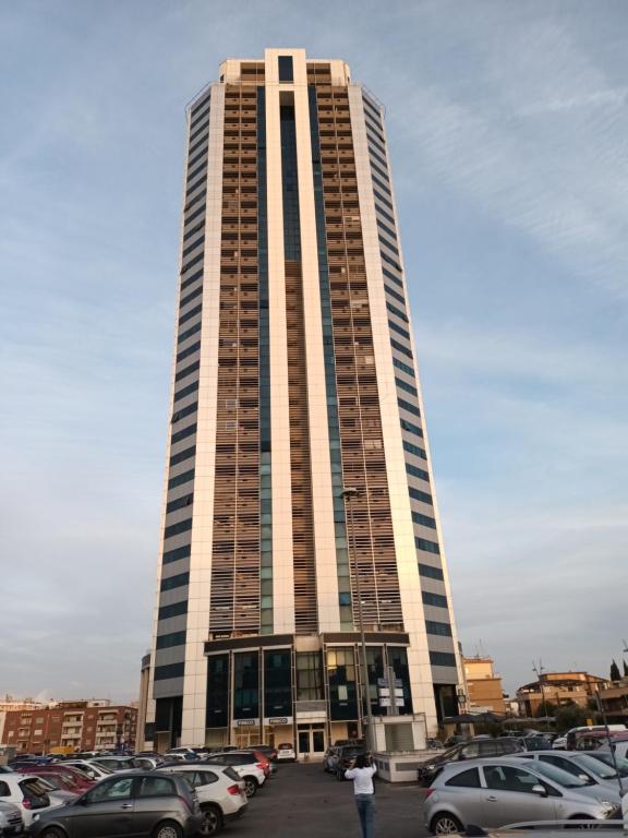 wysoki budynek z samochodami zaparkowanymi na parkingu w obiekcie La torre w mieście Latina