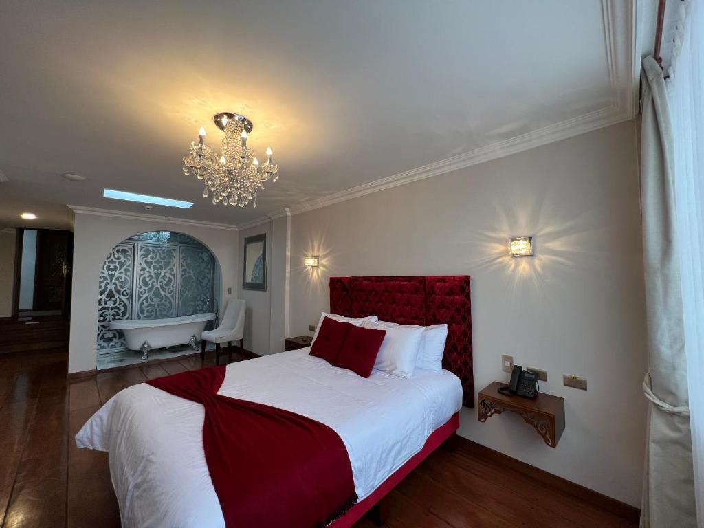 um quarto com uma cama grande e um lustre em Dakani Hotel Boutique NEW em Quito