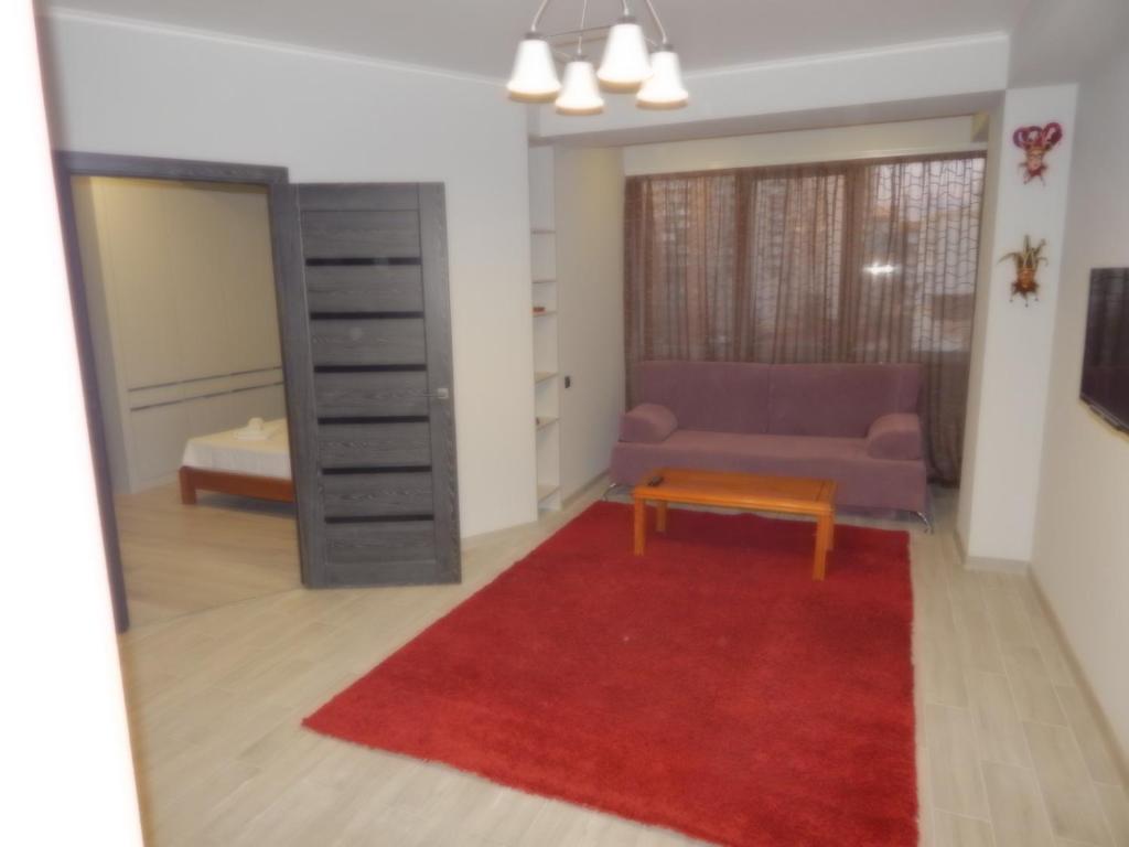 a living room with a couch and a red rug at Confortable apartment in Chişinău