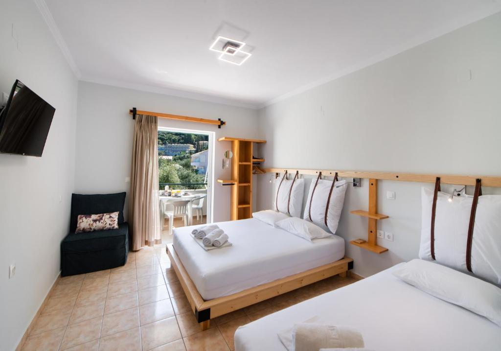 a hotel room with two beds and a television at Nikolas Studios in Agios Nikitas