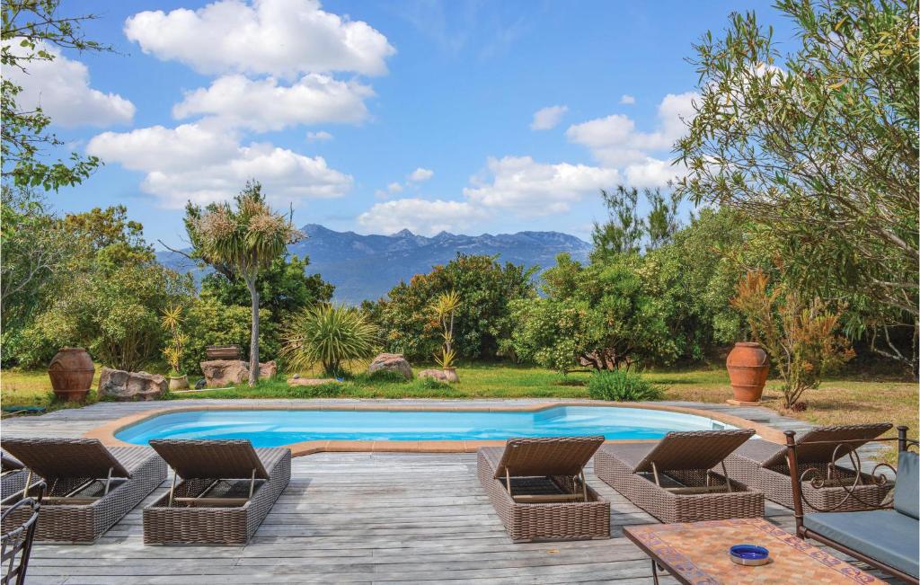 una piscina con sedie, tavolo e montagne di Awesome Home In Figari With 4 Bedrooms, Private Swimming Pool And Outdoor Swimming Pool a Figari