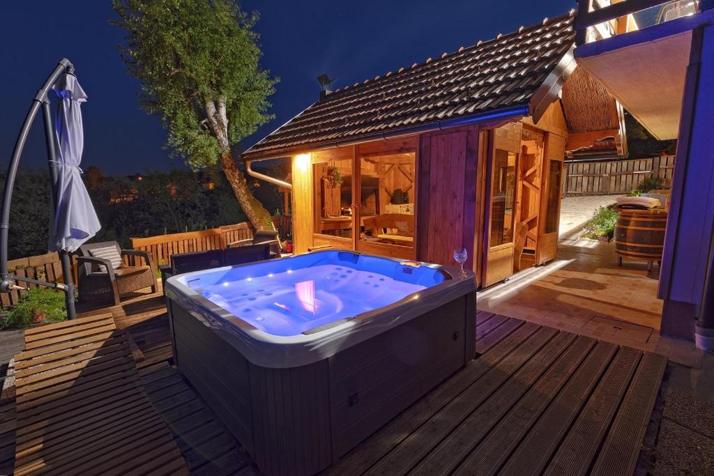 a hot tub on a deck with a house at Holiday Spa House Kostanjevec in Velika Gorica