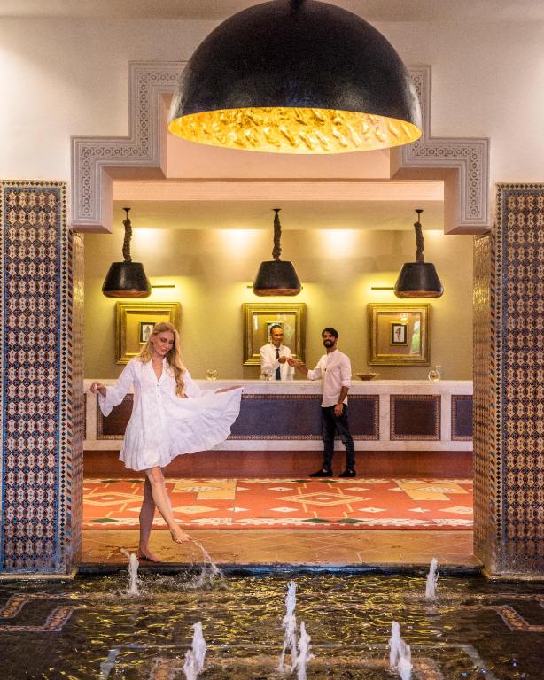 a woman in a white dress dancing in a fountain at Berbère Palace in Ouarzazate