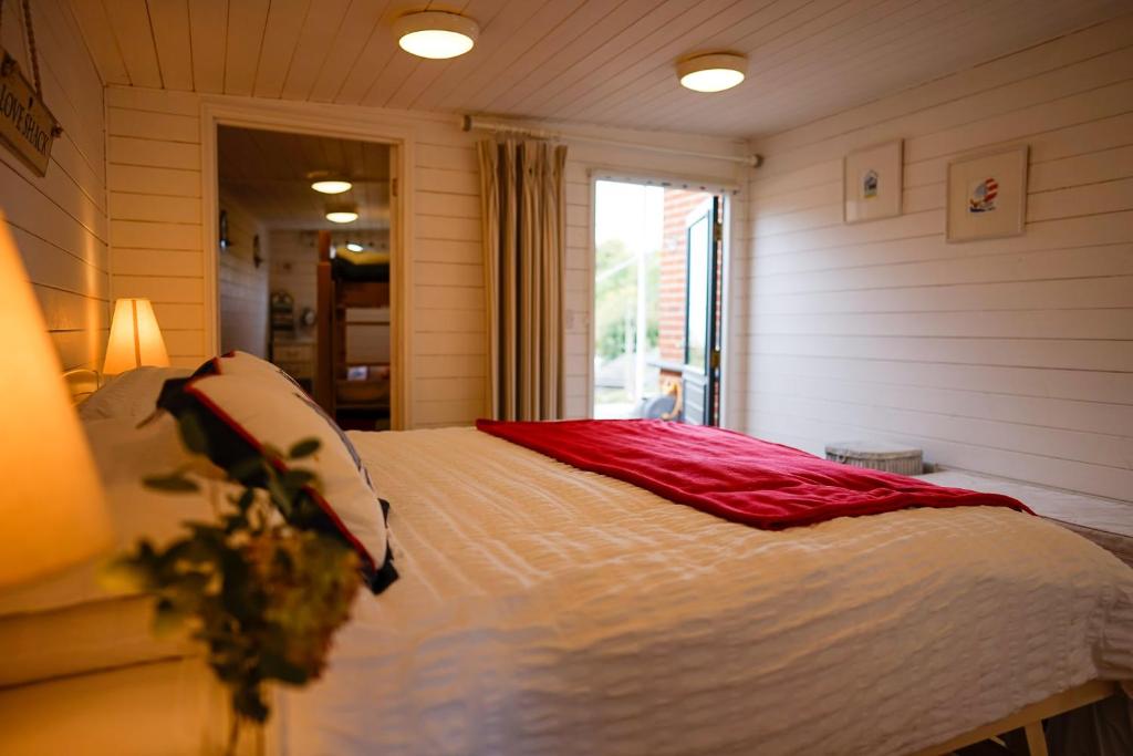 ein Schlafzimmer mit einem Bett in einem Zimmer mit einem Fenster in der Unterkunft Seagrove Beach Cabin in Seaview