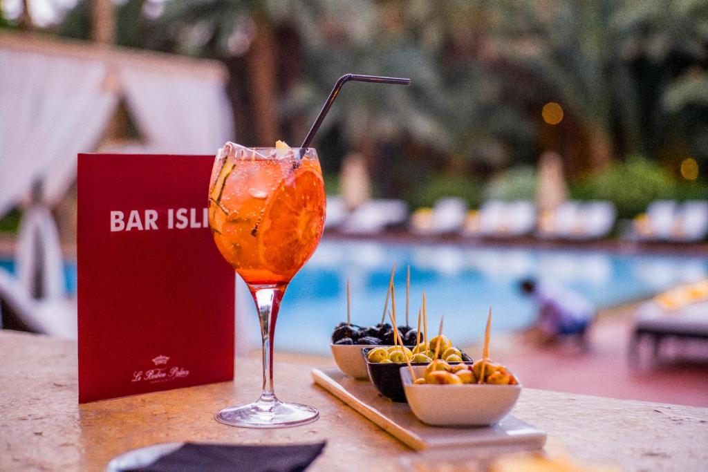 a drink sitting on a table next to a bowl of fruit at Berbère Palace in Ouarzazate