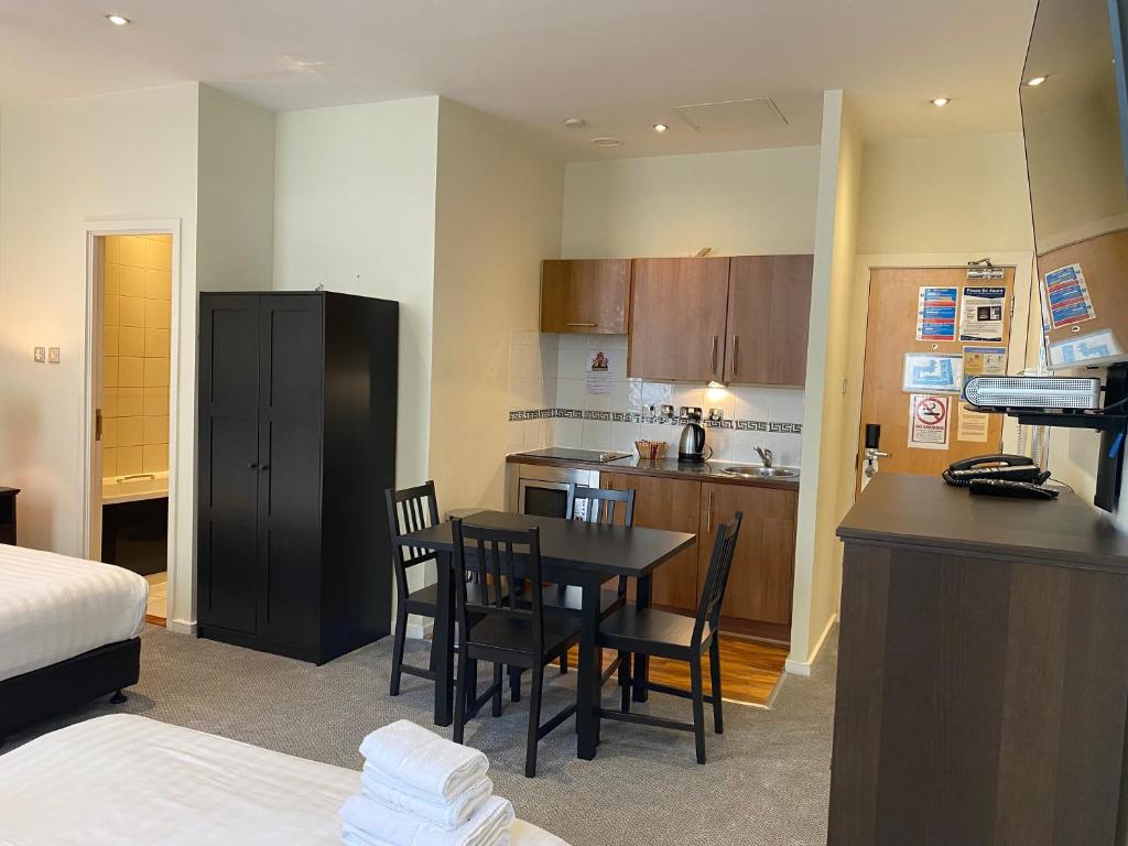 a kitchen with a table and chairs in a room at Grand Plaza Serviced Apartments in London