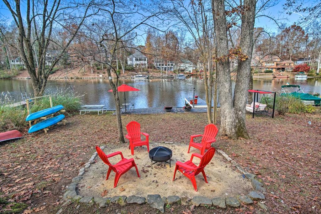 um grupo de cadeiras vermelhas em torno de uma fogueira ao lado de um lago em Locust Grove Lake House Swim, Boat and Unwind! 