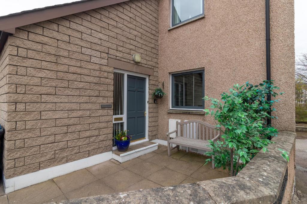 une maison avec un banc devant une porte dans l'établissement Fishertown House, à Nairn