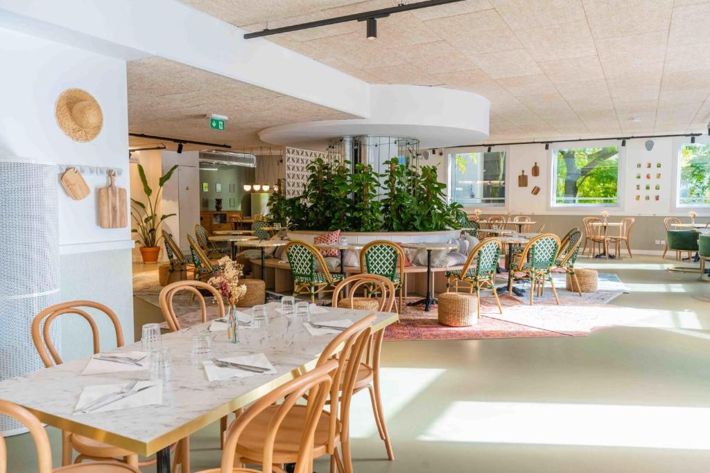 une salle à manger avec des tables et des chaises ainsi qu'un restaurant dans l'établissement Ecla Paris Noisy-le-Grand, à Noisy-le-Grand