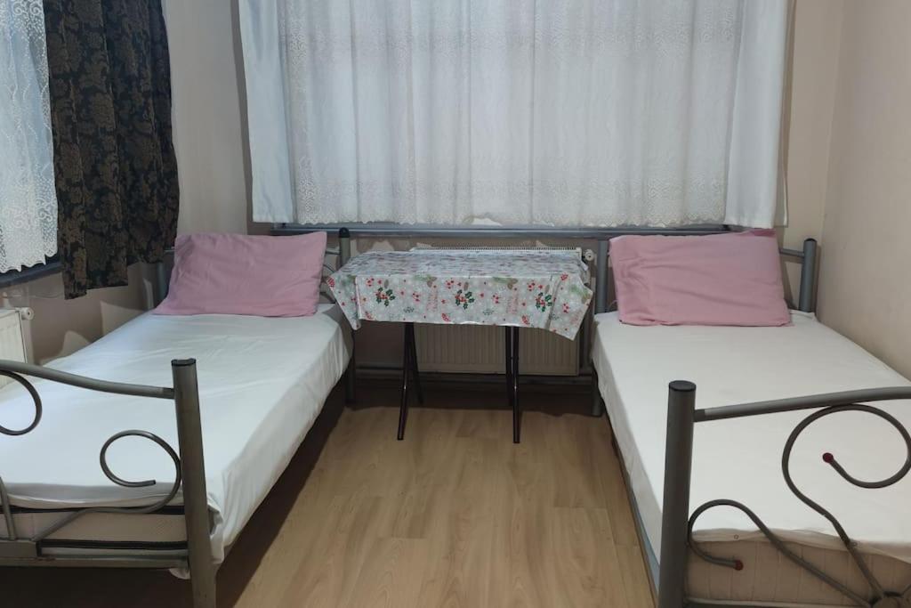 - 2 lits dans une petite chambre avec une table dans l'établissement 2+1 Aileye Uygun Haftalik ve Aylik, à Istanbul