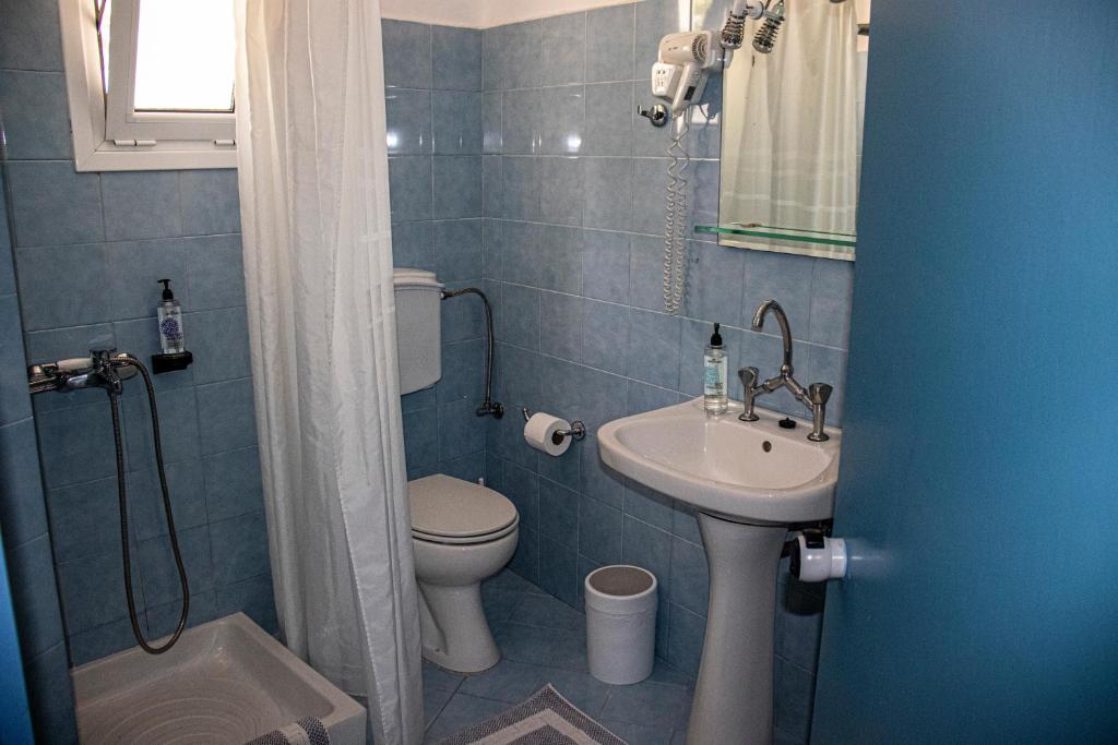 a small bathroom with a toilet and a sink at Castri Village Hotel in Palekastron