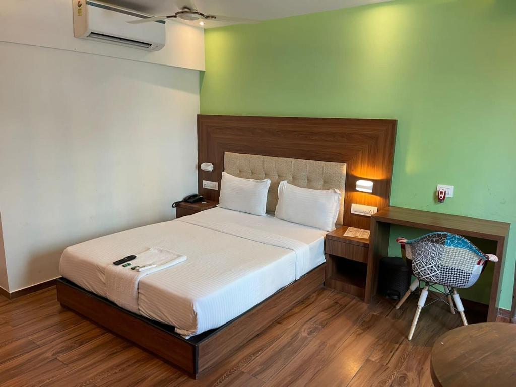a bedroom with a bed and a desk and a chair at Hotel Byaris International By Bizzgrow Hotels in Mumbai