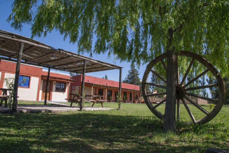 a large wheel sitting in the grass next to a building at Rincón Azul in San Rafael