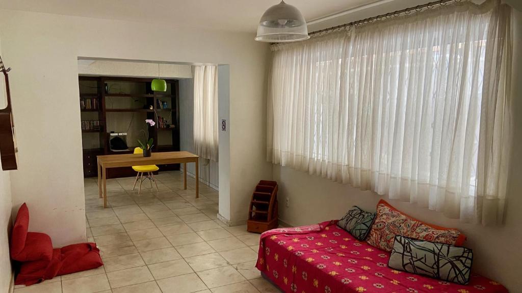 uma sala de estar com um sofá vermelho e uma mesa em Vila Santê em Belo Horizonte