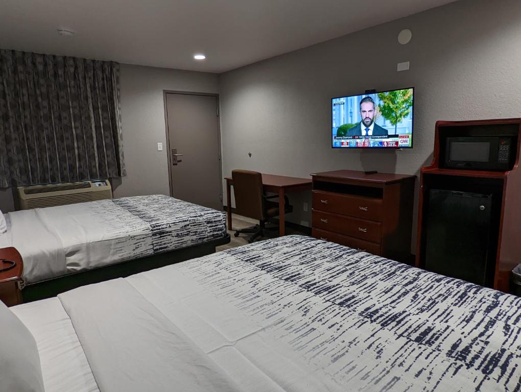 a hotel room with two beds and a flat screen tv at OKC Hotel in Oklahoma City