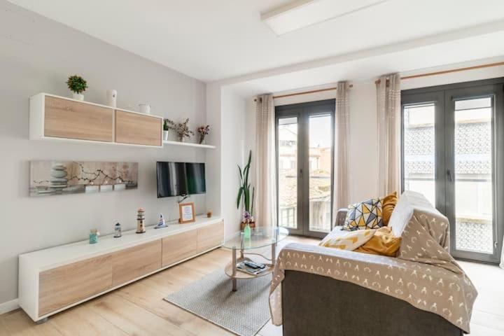 ein Wohnzimmer mit einem Sofa und einem Glastisch in der Unterkunft Apartamento Casa da barbeira in Cangas