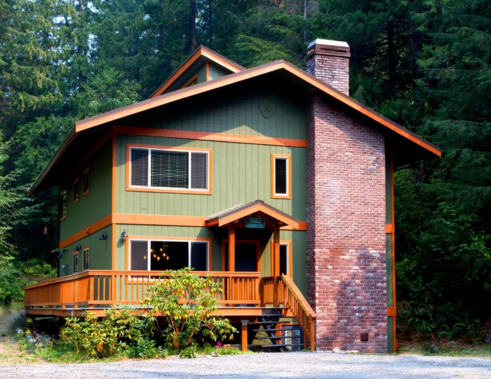 una casa verde con un balcón en el lateral. en Silver Peak Lodge, en Glacier