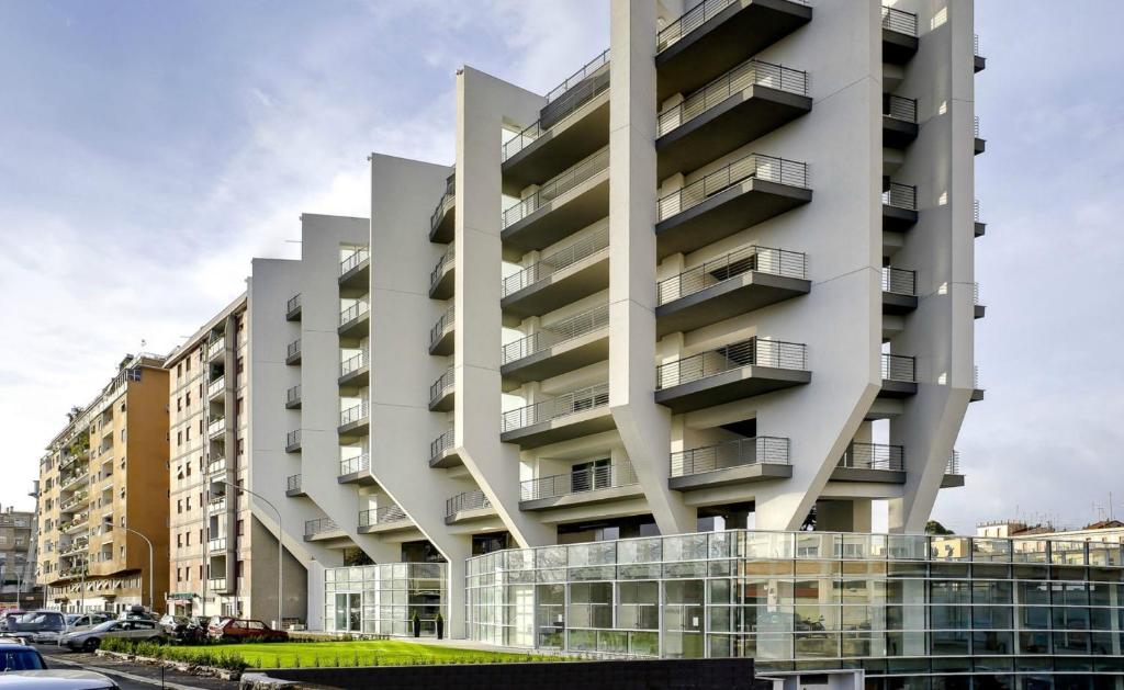 Un grand bâtiment blanc avec balcon se trouve dans une rue. dans l'établissement Lungotevere Suite, à Rome