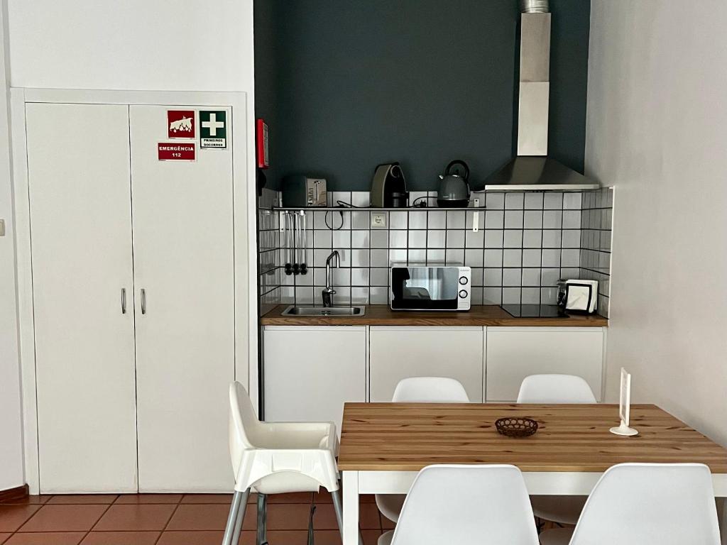 ペーゾ・ダ・レーグアにあるImperial Douro Apartamento 1のキッチン(木製テーブル、白い椅子付)