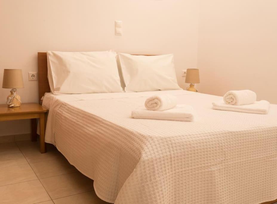 Un dormitorio con una cama blanca con toallas. en Come & Stay apt, en Ierápetra