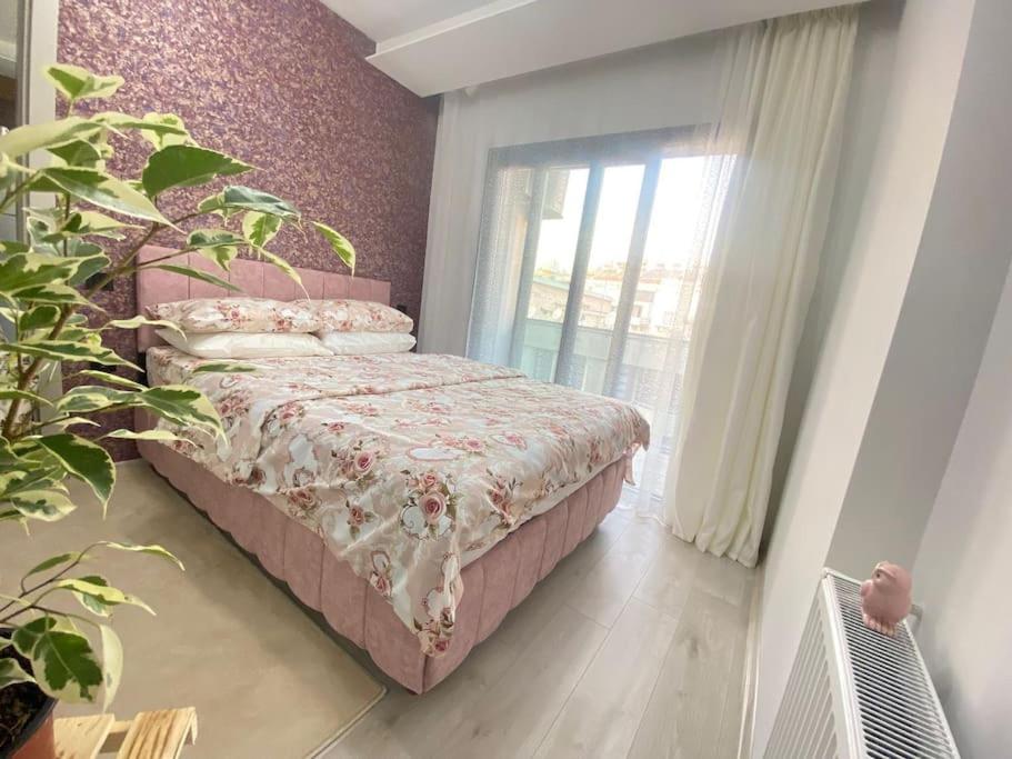 a bedroom with a bed and a plant and a window at Merkezi konumda yeni dekore edilmiş şık daire in Mersin