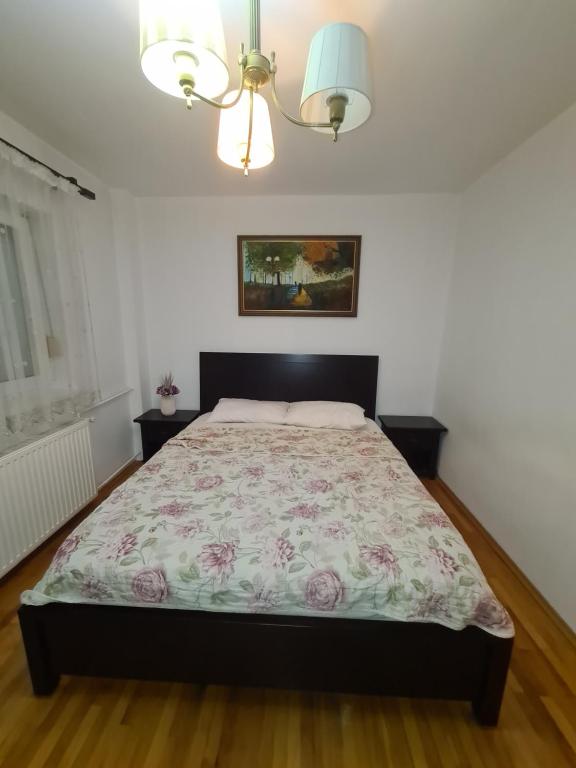 Un dormitorio con una cama con una colcha floral. en Clasic Apartment Nufarul, en Oradea