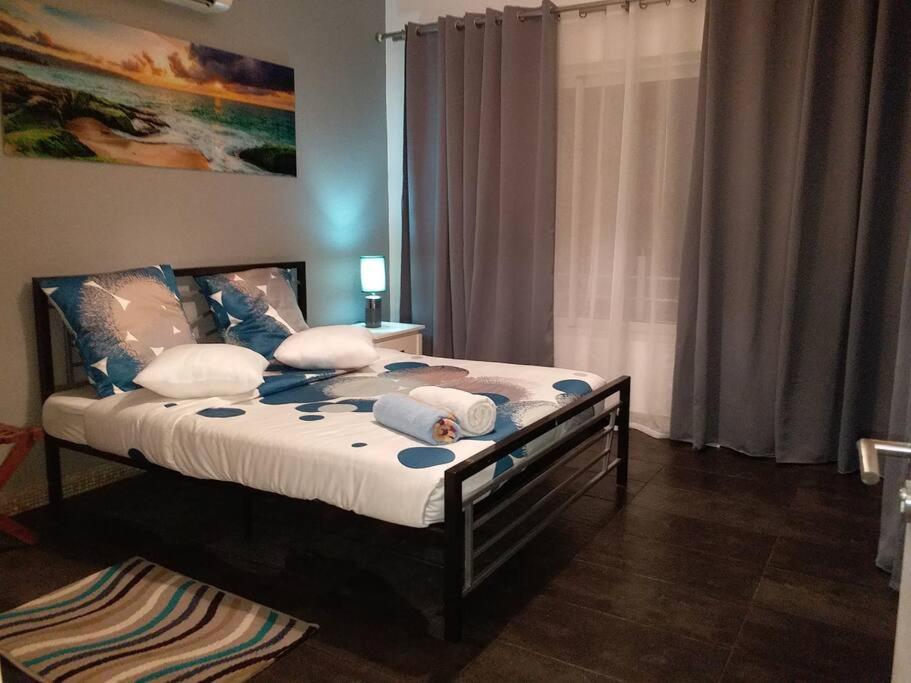 a bedroom with a bed with blue and white pillows at Beachfront Apartment(roadside- 30 meters to beach) in Flic-en-Flac