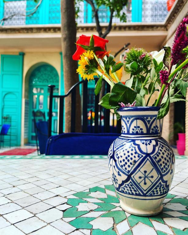 a blue and white vase with flowers in it at Riad Al Nour in Marrakech
