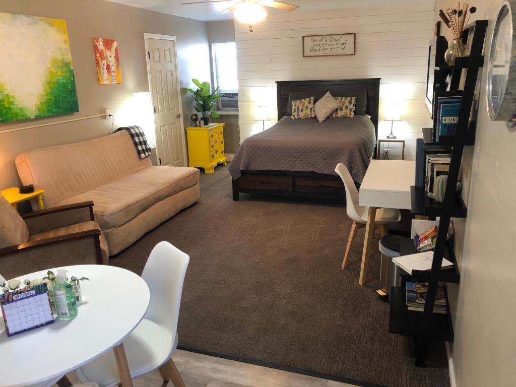 a bedroom with a bed and a couch and a table at Cozy Studio in Grand Junction