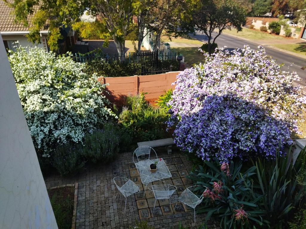 a garden with purple and white flowers and baskets at Aan die Voet van die Magalies in Pretoria