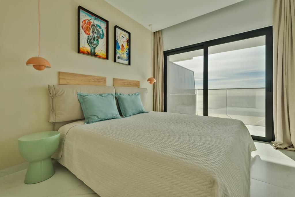 sypialnia z łóżkiem i dużym oknem w obiekcie SUNSET sea view apART w mieście Benidorm