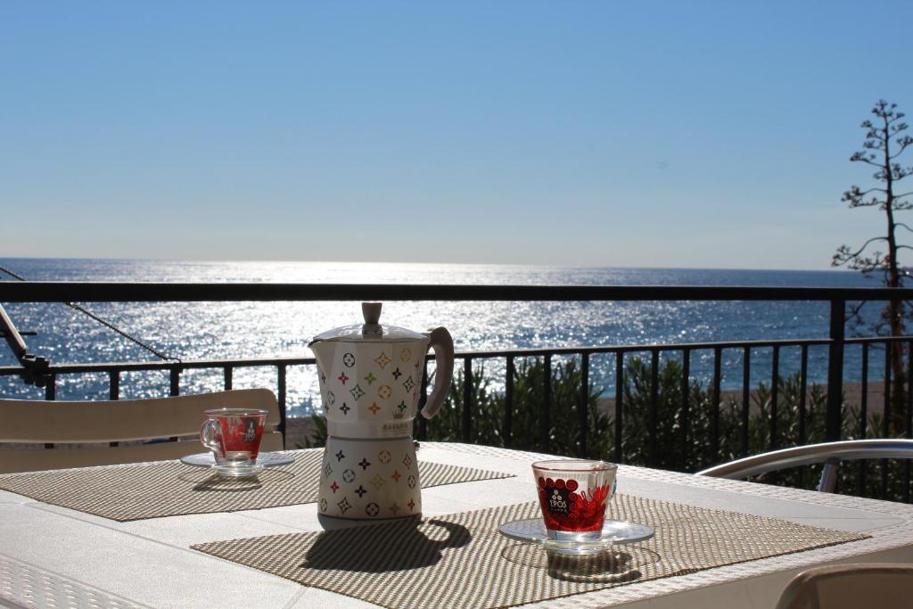 a table with a vase and glasses on a balcony at I Cardellini in Mascali