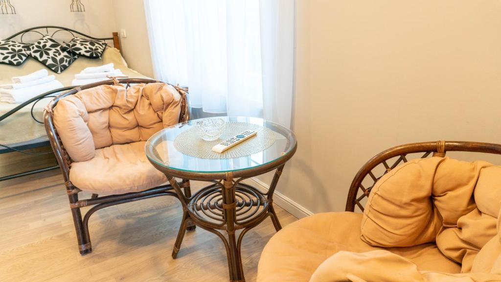 Cette chambre comprend une table, une chaise et un lit. dans l'établissement Apartamentai Gastrolės, à Palanga