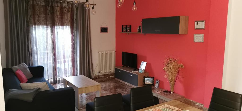 sala de estar con pared roja y TV en Almagro a un paso, en Almagro
