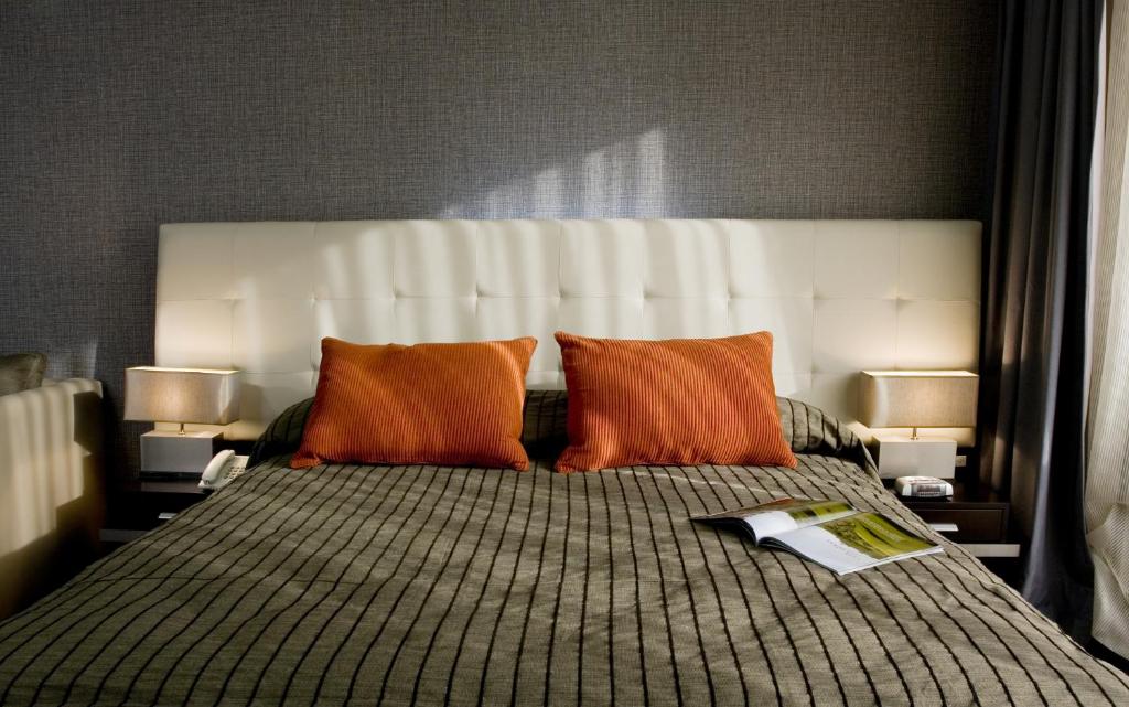 1 dormitorio con 1 cama con 2 almohadas de color naranja en Recoleta Plaza by Ayres en Buenos Aires