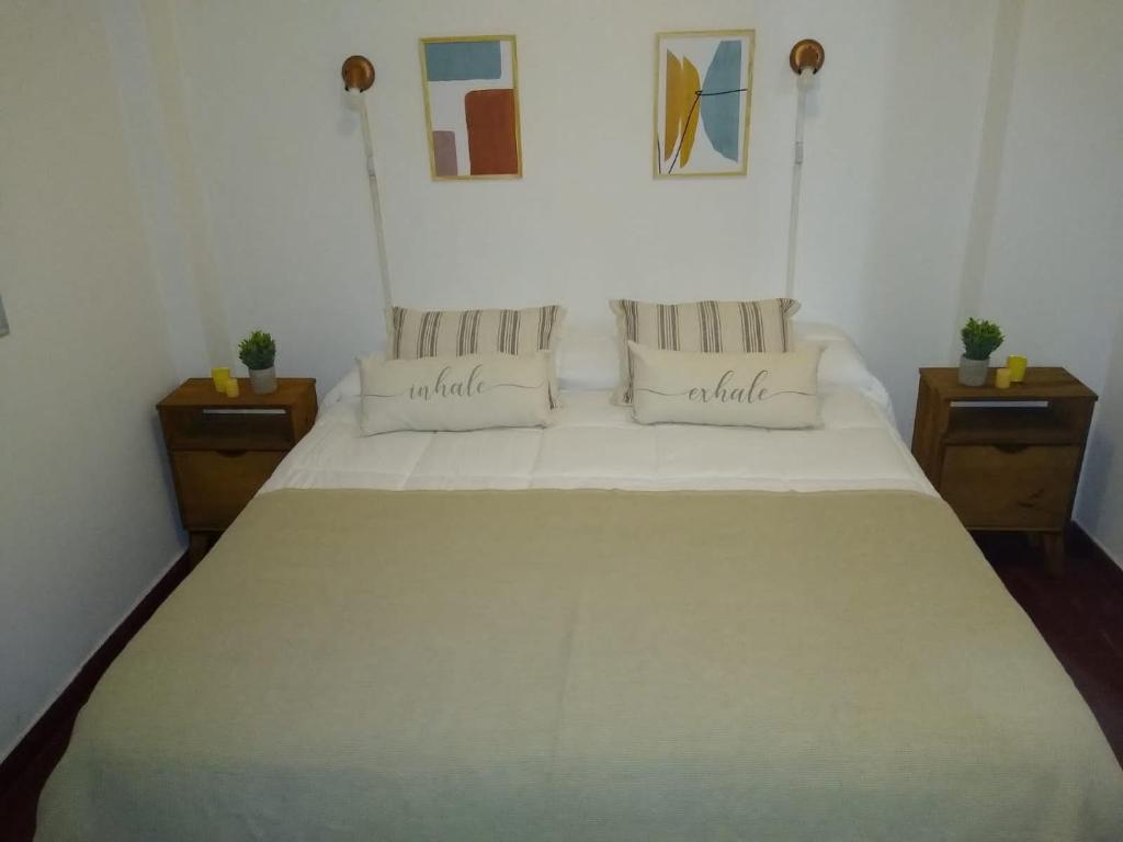 1 dormitorio con 1 cama blanca grande y 2 mesitas de noche en Departamento 20 de Febrero Premium en Salta