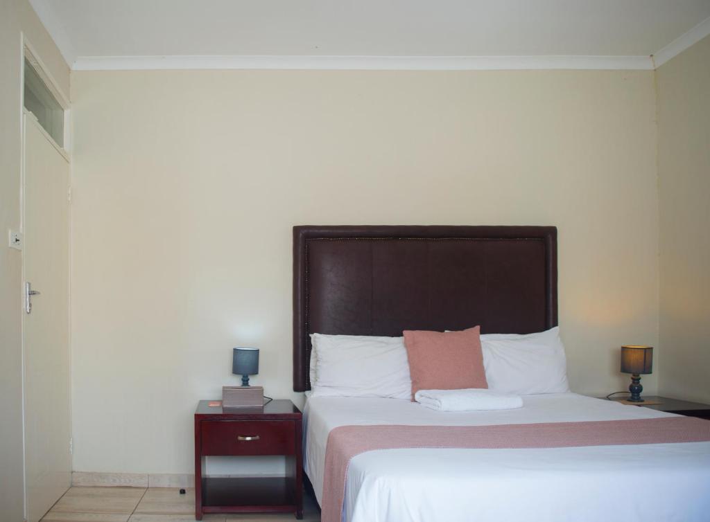 ein Schlafzimmer mit einem großen Bett mit einem großen Kopfteil in der Unterkunft Haithoms Guesthouse in Gaborone