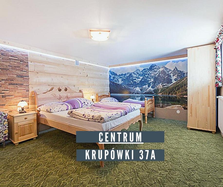 ザコパネにあるWesoła Chatka - Krupówki 37a -CENTRUMのベッドルーム1室(ベッド2台付)が備わります。壁には絵画が飾られています。