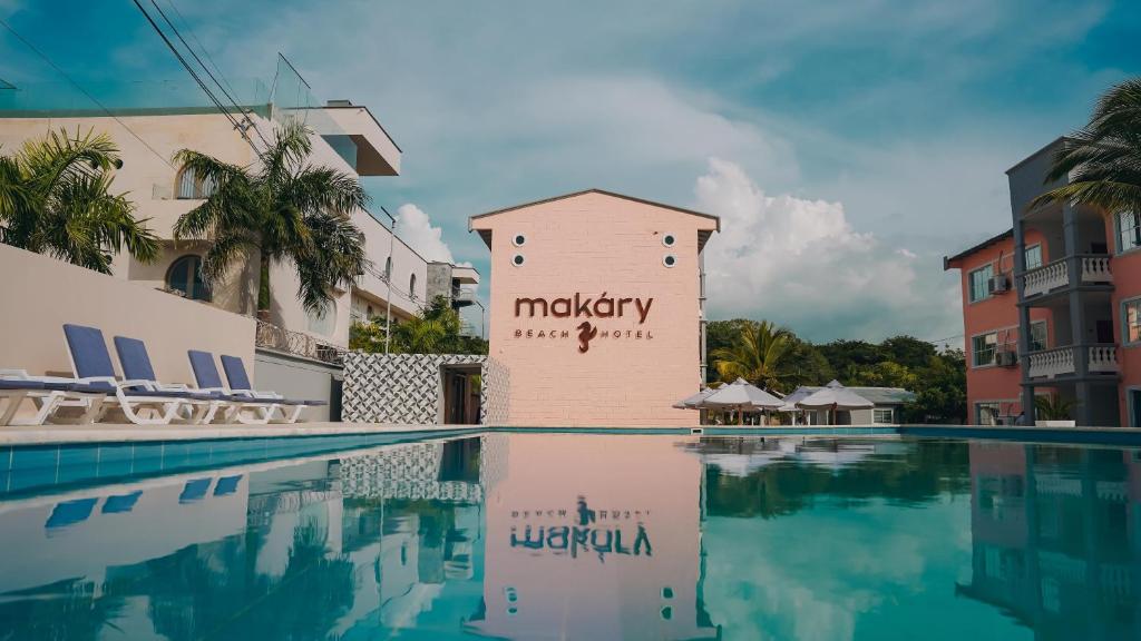 a swimming pool in front of a building at MAKARY BEACH HOTEL in Tolú