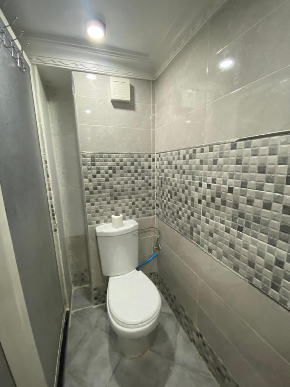 ein Bad mit WC und gefliesten Wänden in der Unterkunft Ayah's Vacation Home in Sidi Yahia az Zaʼer