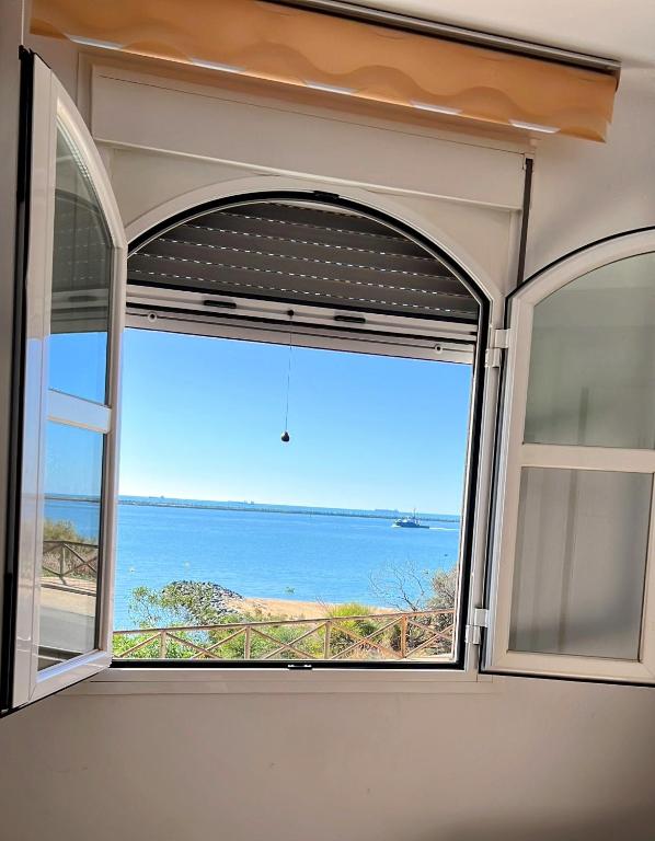 a window in a room with a view of the ocean at Estudios Costavigía Mazagón by Ramona in Mazagón