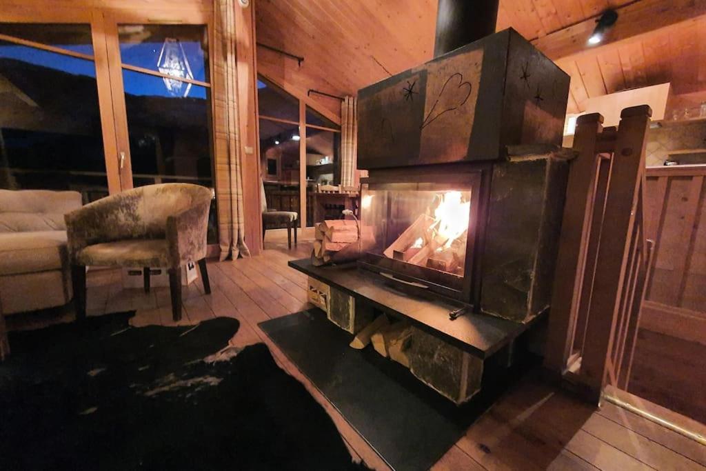 una sala de estar con chimenea en una casa en Cosy 4 bedroom chalet with hot tub (Chalet Velours) en Saint-Marcel