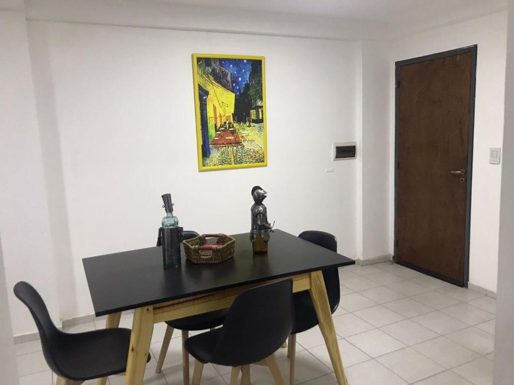 una mesa de comedor con sillas y una pintura en la pared en Complejo Rodriguez Peña en Córdoba